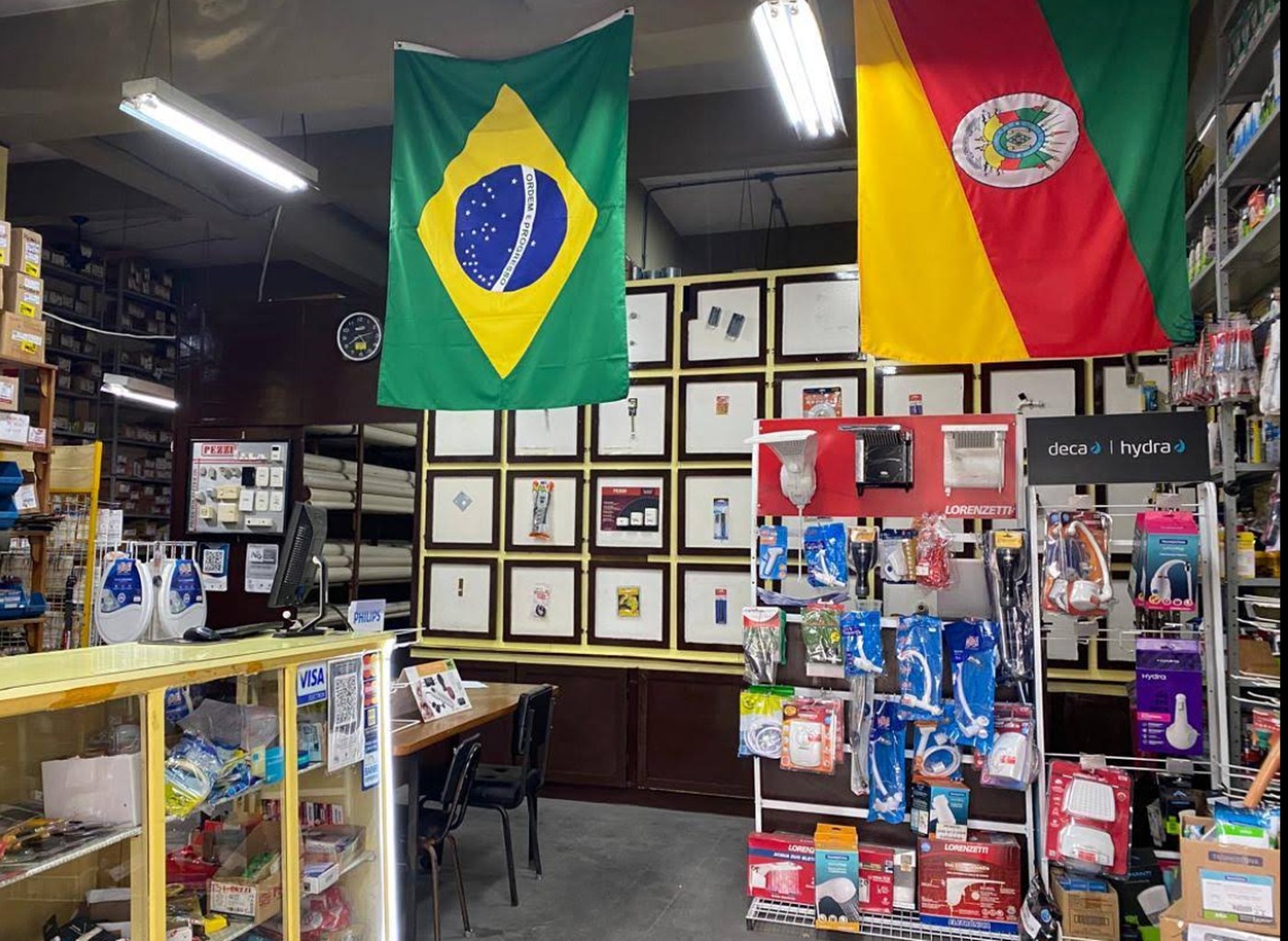 Interior da loja Eletro Veiga com bandeiras do Brasil e do Rio Grande do Sul